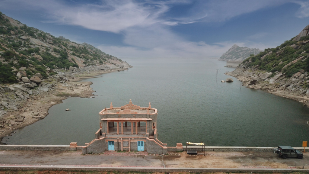10 Hidden Gems in India Every Traveler Must Visit once Scenic Jawai Dam in Rajasthan surrounded by rocky hills and calm waters with a small architectural structure in the foreground