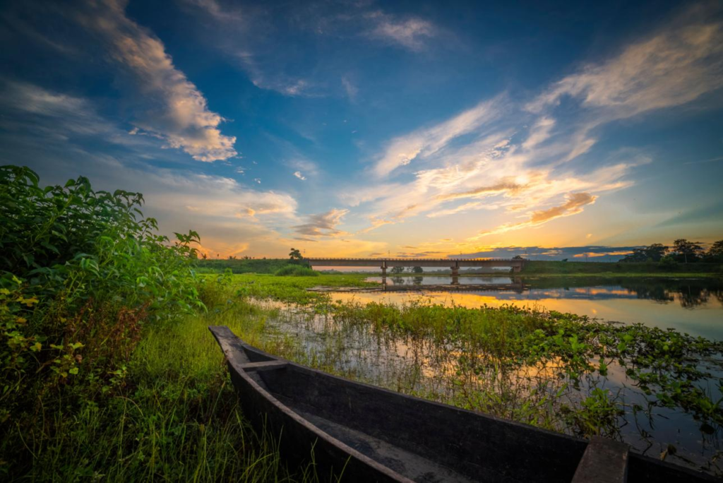 10 Hidden Gems in India Every Traveler Must Visit once Traditional wooden boat by the riverside in Majuli, Assam during sunset, a peaceful place to visit in India